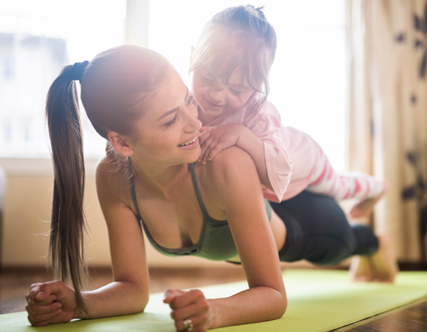 Woman exercising with daughter on back