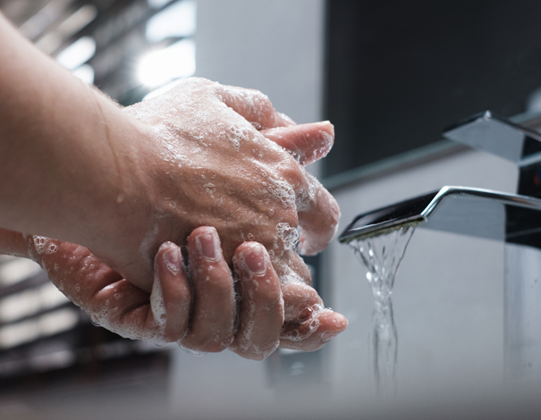 person washing hands to avoid spreading germs and viruses