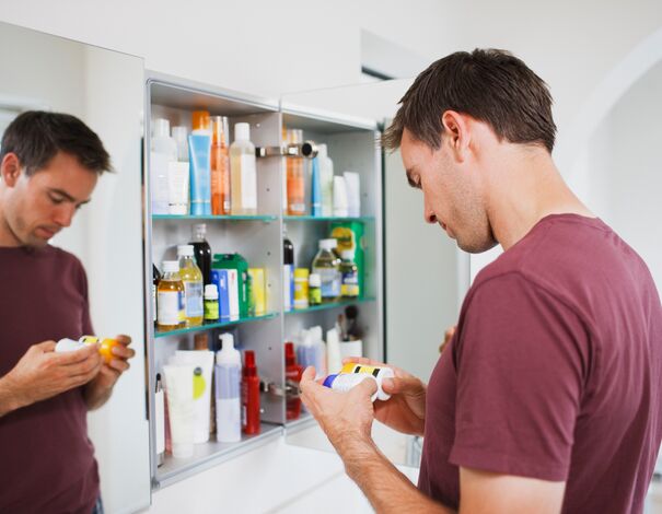 Un homme fait le ménage de sa pharmacie à médicaments pour la saison de la grippe