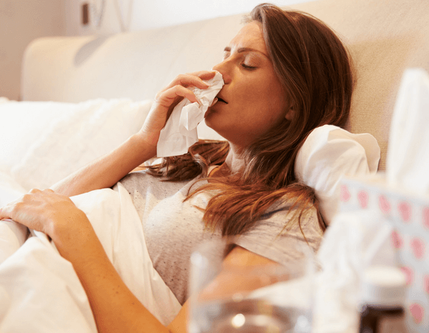 femme au lit avec symptômes de la grippe, rhume ou covid-19
