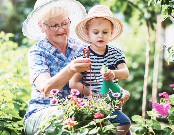 Grandmother outside gardening with grand-daughter
