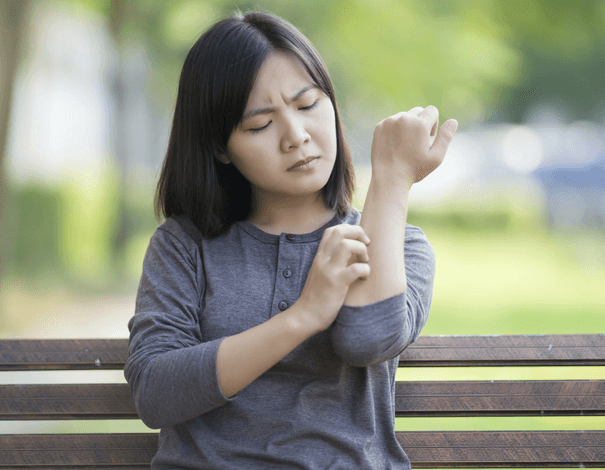 Woman scratching her arm because of a Skin Rash