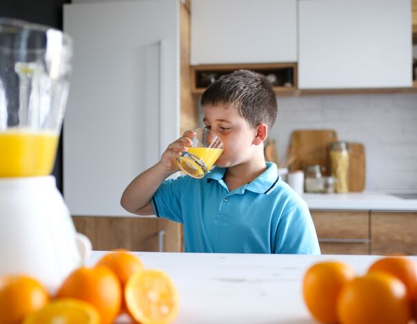 Child drinking orange juice to prevent cold